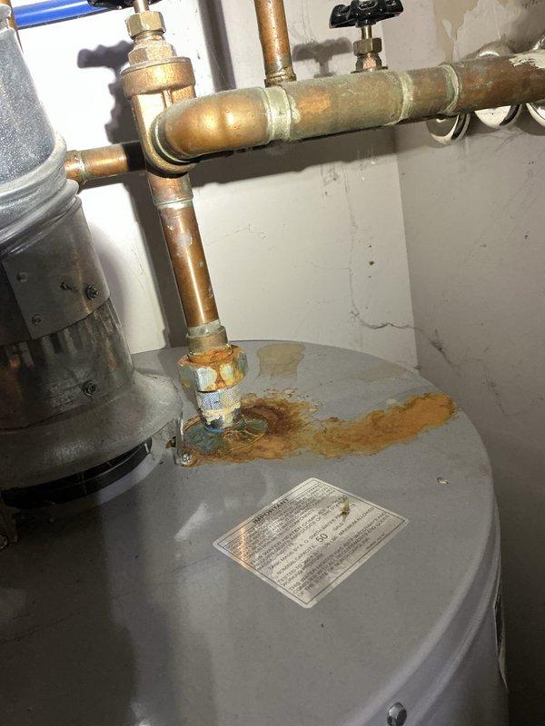 Performed comprehensive tune-up and city certification inspection on 24-year-old furnace system located in utility room. Conducted full system diagnostics including blower motor assembly inspection, gas valve operation verification, igniter and flame sensor testing, and electrical connection assessment. Also documented significant rust and corrosion on water heater tank top near copper pipe connections, indicating potential leak concerns that may require future attention. All furnace components found operational and system certified for continued use.