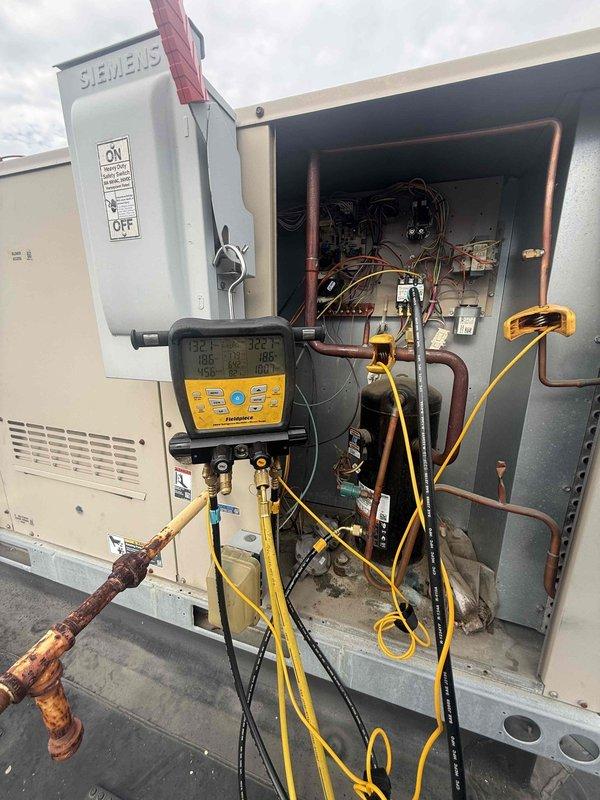 Responded to no cooling complaint on two rooftop AC units. Upon arrival, accessed roof and connected digital manifold gauges to both systems to diagnose refrigerant pressures and temperatures. Inspected electrical disconnects, control panels, and copper refrigerant lines, noting significant corrosion on exterior line sets. Performed system diagnostics using Fieldpiece manifold gauge set to measure operating pressures, superheat, and subcooling values. Evaluated compressor operation, electrical connections, and control circuitry. Identified cooling deficiencies and documented system conditions with pressure readings and visual inspection of deteriorated components. Both RTU systems assessed and diagnostic testing completed to determine root cause of inadequate cooling performance.