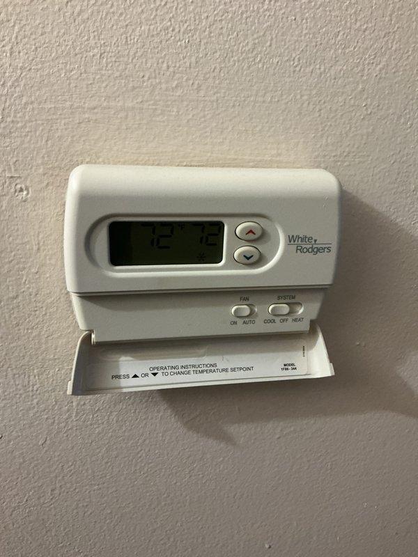 Completed comprehensive furnace tune-up and inspection on 10-year-old forced air unit located in basement. Verified White-Rodgers programmable thermostat operation and temperature control functionality. Inspected heat exchanger and evaporator coil, noting significant accumulation of dust and contaminants on lower fin sections requiring attention. Documented equipment condition with photographic evidence showing brownish-tan discoloration on coil fins indicating reduced efficiency. All system components assessed for proper operation and safety compliance.