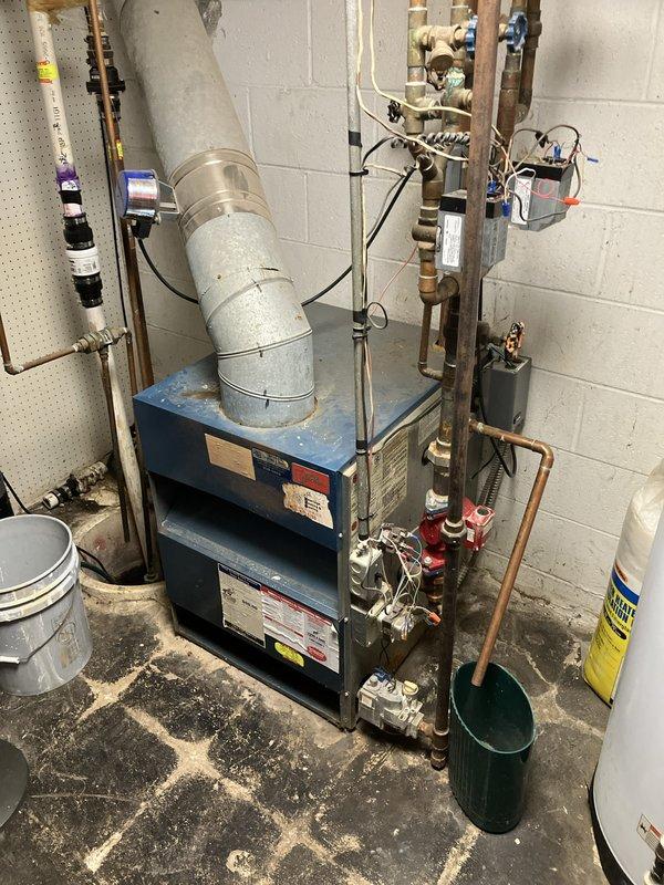 Completed estimate for replacement of 38-year-old natural gas-fired hot water boiler serving baseboard heating system. Existing unit determined to be non-operational due to cracked heat exchanger, rendering it unsafe for continued use. Assessment included evaluation of current hydronic piping configuration, circulator pump assembly, expansion tank, zone valves, and electrical controls to determine scope of replacement work required for new boiler installation.