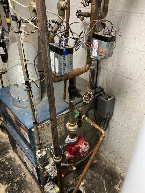 Completed estimate for replacement of 38-year-old natural gas-fired hot water boiler serving baseboard heating system. Existing unit determined to be non-operational due to cracked heat exchanger, rendering it unsafe for continued use. Assessment included evaluation of current hydronic piping configuration, circulator pump assembly, expansion tank, zone valves, and electrical controls to determine scope of replacement work required for new boiler installation.