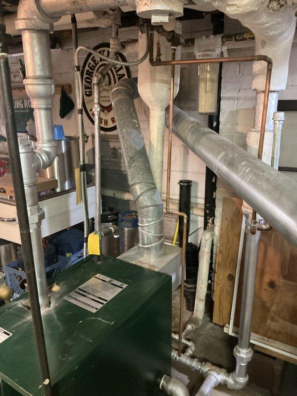 Conducted boiler replacement estimate for existing green metal unit with failed heat exchanger causing active water leak. Assessed hot water heating system with circulator pump and associated piping infrastructure in basement mechanical room. Documented current equipment condition and configuration to provide comprehensive replacement recommendations for failed boiler system.