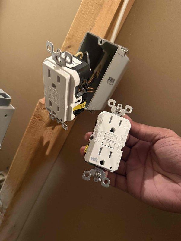 Returned to site to replace defective GFCI outlet. Removed existing GFCI receptacle from electrical box mounted in wall framing and installed new white GFCI outlet with proper wiring connections to copper conductors. Verified proper operation of test and reset functions, confirmed ground fault protection is working correctly, and tested both receptacles under load with connected devices showing normal operation with indicator lights functioning as designed.
