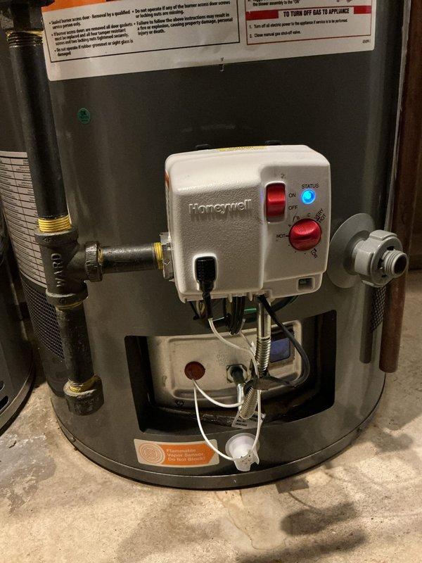 Removed and replaced defective flammable vapor sensor and associated wiring harness on residential gas water heater. Disconnected faulty sensor assembly from Honeywell gas control valve, installed new vapor sensor unit with updated wiring harness, and verified proper electrical connections. Tested gas control operation and confirmed sensor functionality with status indicator showing normal operation upon completion.