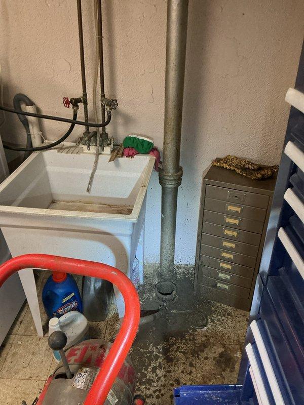 Responded to a clogged basement laundry room drain requiring mechanical snaking. Upon arrival, found standing water on the floor indicating a complete blockage in the drainage system. Successfully cleared the obstruction using a drain snake through the floor drain, restoring proper water flow and drainage function. Verified the utility sink plumbing connections and main drain stack were functioning correctly with no additional clogs or backup issues detected.
