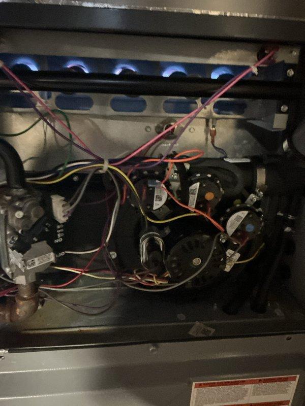 # Concise Summary

Completed Gold AC inspection on 2-year-old residential system with 1 outdoor condensing unit and 2 furnaces, all equipment operational. Performed comprehensive multi-point inspection including burner operation verification with visual confirmation of proper flame characteristics, electrical component assessment, and exterior unit evaluation of model 18GN848-A (R410A refrigerant system). Documented system conditions through photographic evidence showing active burner assembly with proper blue flame pattern, control components, and outdoor unit specifications.

# Detailed Technical Description

Performed comprehensive Gold AC inspection on residential HVAC system consisting of one air conditioning unit and two gas furnaces, all approximately 2 years old with air handler located in basement. Conducted thorough multi-point inspection protocol on all equipment.

**Furnace Inspection:**
Removed access panels and inspected internal components of both gas furnaces. Verified 