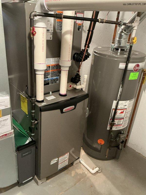Completed comprehensive Gold Furnace Inspection on 10-month-old Lennox HVAC system and water heater located in basement mechanical room. Performed thorough visual inspection of furnace unit, verifying proper installation of ductwork connections, PVC condensate drainage system, and venting components. Inspected all accessible components including heat exchanger, blower assembly, gas connections, and electrical controls. Verified proper operation of safety devices and thermostat communication. Examined air conditioning system components and confirmed refrigerant lines, condensate drain, and electrical connections were secure and functioning properly. Checked water heater integration with HVAC system including all piping connections and pressure relief valves. All equipment found operating within manufacturer specifications with no deficiencies noted. System demonstrated proper airflow, ignition sequence, and temperature differential. Provided homeowner with maintenance recommendations fo