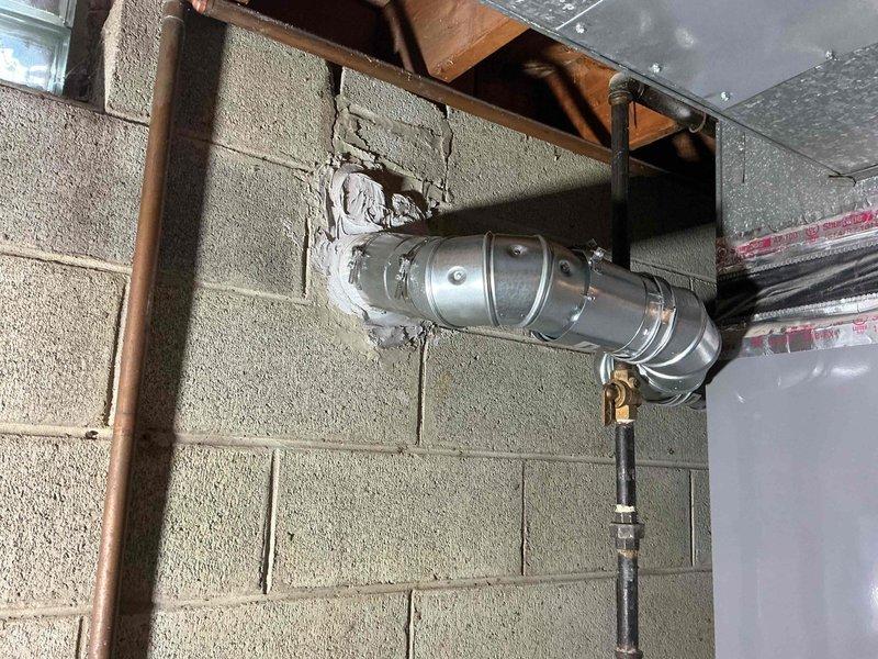 Returned to property for second violation correction on water heater flue installation. Previous repair was rejected by inspector due to improper use of elbow fitting in single-wall flue connector, which exceeded the 6-foot maximum allowable length. Corrected the flue connector configuration by removing the improvised elbow connection and installing compliant venting that meets code requirements for single-wall flue pipe length restrictions. Documented the corrected installation with photographs for inspector approval prior to leaving the premises.