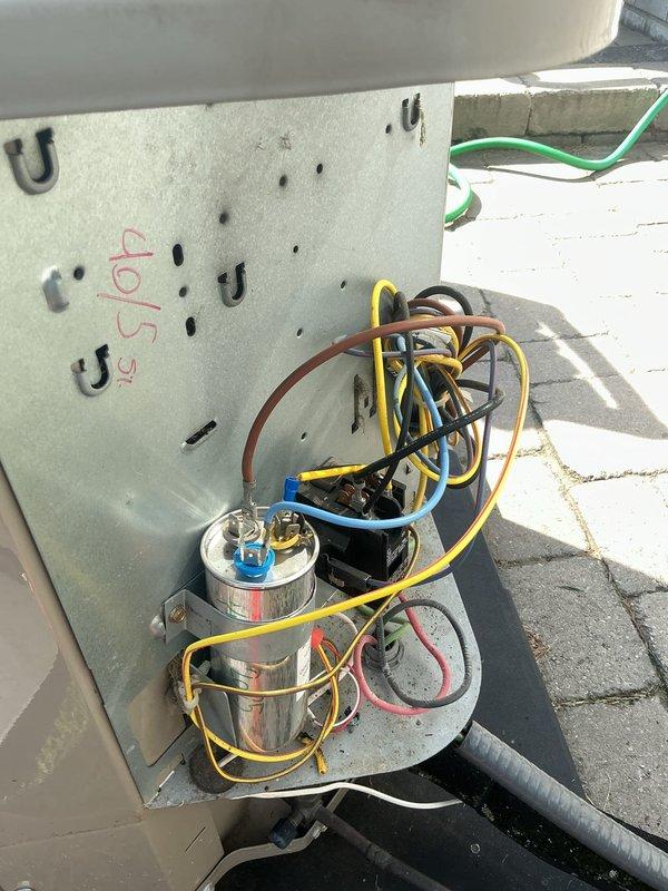 # HVAC Service Completed

Responded to a no cooling call on a 12-year-old residential air conditioning system. Upon arrival, performed diagnostic inspection of the outdoor condensing unit located on the rooftop. Visual inspection revealed burned and deteriorated wiring at the run capacitor connection point, with visible charring on the black wire terminal. The damaged wiring prevented proper electrical flow to the compressor and fan motor, resulting in system failure and loss of cooling capacity.

Disconnected power to the unit and removed the failed capacitor with compromised wire connections. Stripped back damaged wiring to clean copper, installed new run capacitor with proper microfarad rating for the system, and made secure electrical connections to the contactor and motor terminals using appropriate wire nuts and terminal connections. Verified all wire connections were tight and properly insulated.

Restored power to the unit and tested system operation. Confirmed compressor and c