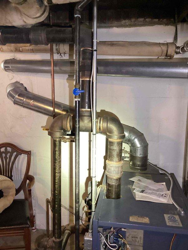 Responded to annual heating inspection request for ten-year-old basement boiler under Gold Plan maintenance. Upon arrival, performed comprehensive diagnostic evaluation of steam boiler system and conducted combustion analysis testing. Testing revealed elevated carbon monoxide levels in flue gas, indicating incomplete combustion and potential safety hazard requiring immediate attention.

Conducted thorough visual inspection of boiler unit, heat exchanger, burner assembly, venting system, and associated piping infrastructure. Examined blue-painted boiler cabinet, copper supply and return lines, galvanized venting, brass fittings, and control components. Assessed condition of circulation system including valves, pressure relief devices, and electrical controls. Documented existing equipment configuration with photographic evidence showing piping layout, connection points, ductwork, and overall mechanical room setup.

Based on elevated CO readings and age of equipment, determined that boil