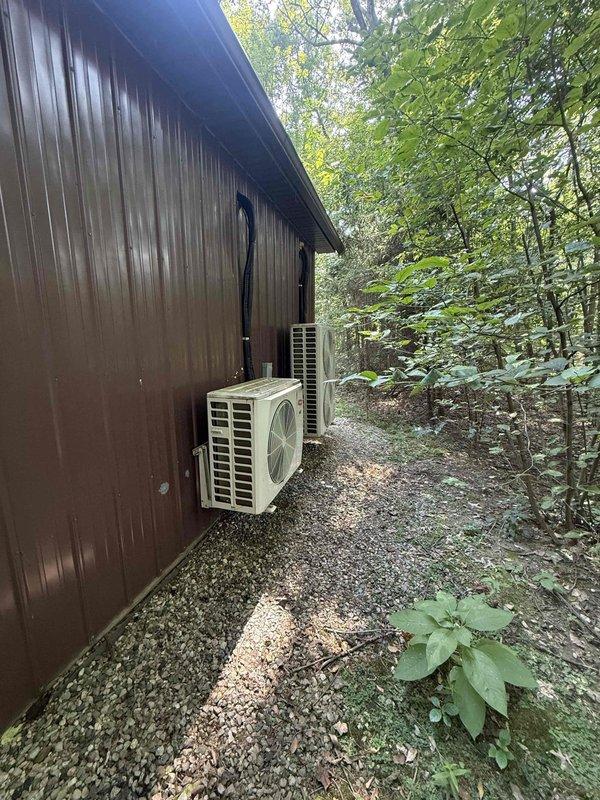 Evacuated R-410A refrigerant from Carrier 4-ton, 4-zone condenser system. Removed wall-mounted indoor head unit from interior location and relocated to exterior wall per specifications. Modified copper lineset routing and extended 14/4 stranded control wiring to accommodate new head unit position. Installed condensate PVC drain line with proper pitch, terminating at grade level. Recharged system with recovered R-410A refrigerant, weighing refrigerant charge into each of the four zones according to manufacturer specifications. Performed system startup, verified proper operation of all zones, and confirmed adequate airflow and temperature differential across all indoor units.