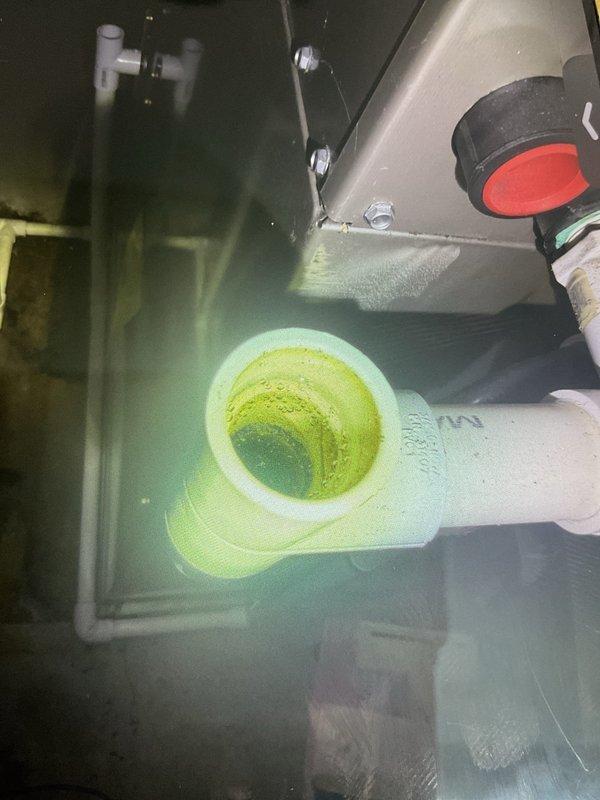 # Water Leak Resolution - 10-Year-Old AC System

Responded to service call for excessive water accumulation around basement HVAC system. Upon arrival, conducted thorough inspection of 10-year-old air conditioning unit and associated drainage components.

**Primary Issue Identified:**
Visual inspection revealed corroded and deteriorating brass condensate drain trap beneath the air handler. Significant oxidation and discoloration observed on metal piping connections, indicating prolonged exposure to moisture and potential failure points in the drainage system.

**Work Performed:**
- Inspected all condensate drain lines and connections from air handler to drainage point
- Examined internal air handler cabinet for signs of water intrusion or overflow
- Photographed corroded brass trap and PVC transition connections showing brown oxidation
- Assessed drain pan condition and primary/secondary drain line functionality
- Verified proper pitch and flow of condensate drainage system
- Checked fo