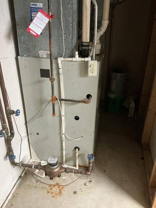 Conducted comprehensive site evaluation for full HVAC system replacement in 1800 square foot condominium unit. Assessed existing furnace installation, ductwork configuration, refrigerant line routing, and condensate drainage system. Documented current equipment condition showing age-related wear, copper pipe oxidation, and standard operational patina on existing components. Evaluated electrical supply, clearance requirements, and mechanical room accessibility for new equipment installation. Photographed existing system layout including furnace cabinet, galvanized ductwork assembly, PVC condensate piping with proper trap configuration, copper refrigerant lines, and utility connections to provide accurate specifications for replacement system proposal. Measured available installation space and confirmed proper ventilation access for future air conditioning and furnace equipment sizing recommendations.