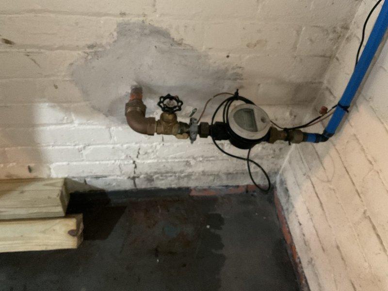 Responded to service call for leaking water heater in basement of 50-year-old residential property. Upon inspection, discovered heavily corroded boiler system with significant rust damage to vertical supply piping and deteriorating infrastructure throughout the mechanical space. Observed extensive water damage and staining on basement walls surrounding the water meter assembly, indicating prolonged moisture intrusion. Customer reported unit losing complete water capacity every 2-3 hours, requiring manual refilling before operation, with leakage occurring from one specific side when system is activated. Unit had not been operated since previous year. Documented existing conditions through photography, capturing severely corroded piping, aged structural components, and water-damaged surfaces. Assessed system for potential auto-fill capabilities as requested. Recommended evaluation by boiler specialist to determine extent of corrosion damage, viability of repairs versus replacement, and f