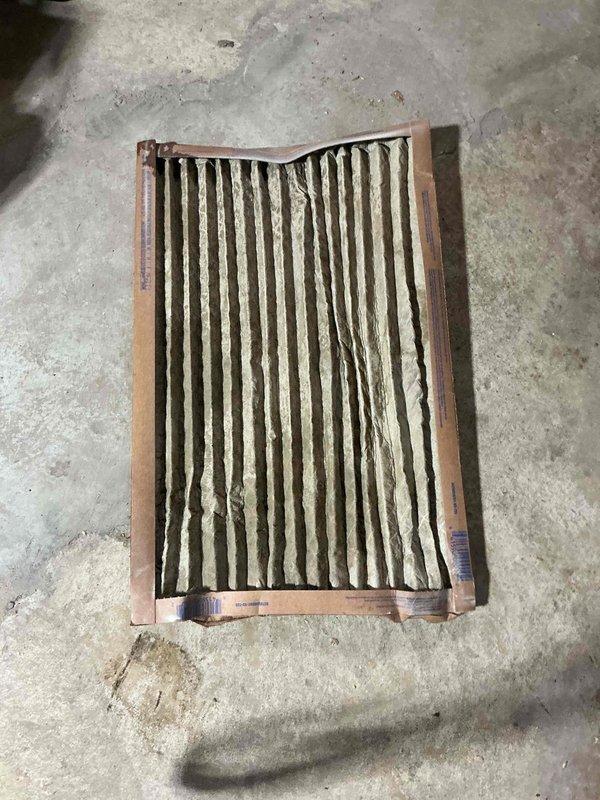 Responded to no cooling complaint on 2021 cooling system located in basement. Upon inspection, found outdoor condenser unit operational but system not achieving proper cooling due to severely restricted airflow. Removed and inspected air filter, which was completely clogged with dirt, dust, and debris, causing significant reduction in system airflow and efficiency. Replaced dirty filter with new filter to restore proper airflow. Verified condenser unit operation and confirmed system returned to normal cooling operation. Homeowner advised on importance of regular filter maintenance to prevent future system issues.