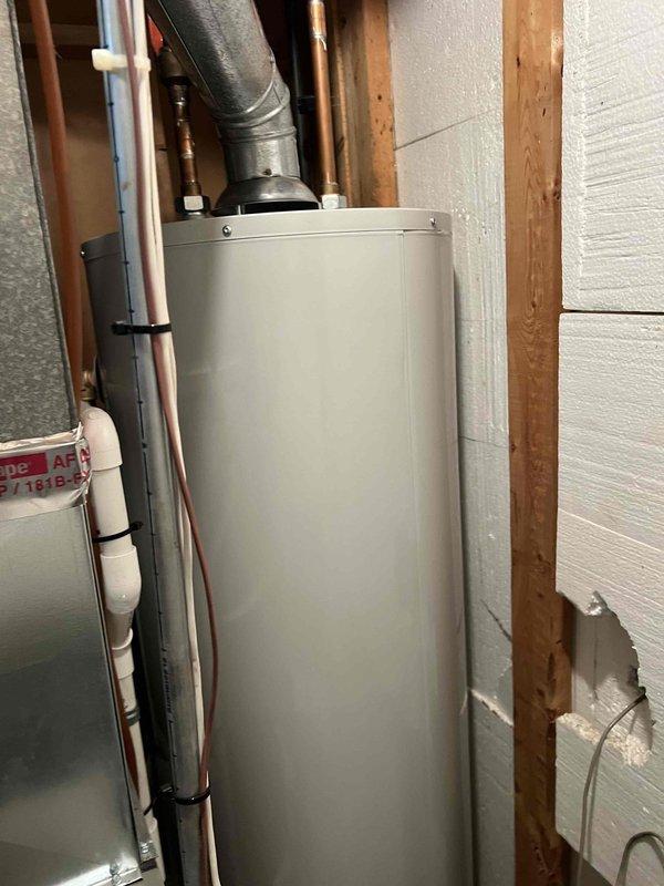 Completed comprehensive Gold AC Inspection on a 10+ year old single-unit system with air handler located in basement. Equipment was operational at time of service. Performed thorough multi-point inspection including visual assessment of air handler installation, refrigerant line insulation, condensate drainage system, and electrical connections. Verified proper PVC condensate drain routing and checked all accessible mechanical components. System found to be functioning within normal parameters. Documentation completed with photographic records of equipment installation and surrounding utility area.