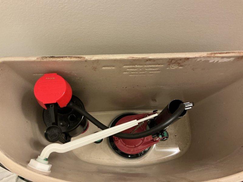 Responded to first-level toilet with continuous running water issue. Upon inspection, removed tank lid and assessed internal flush mechanism components. Identified worn flapper valve failing to create proper seal, allowing water to continuously flow from tank to bowl. Fill valve assembly with float mechanism showed signs of age and mineral buildup contributing to improper water shutoff. Replaced defective red flapper valve with new unit ensuring proper seal against flush valve seat. Adjusted fill valve and float assembly to correct water level specifications. Cleaned mineral deposits from tank rim and internal surfaces affecting component operation. Tested flush cycle multiple times to verify complete water shutoff and proper tank refill. Confirmed no leaks present and all components functioning correctly. Toilet now operating normally with no continuous running water.