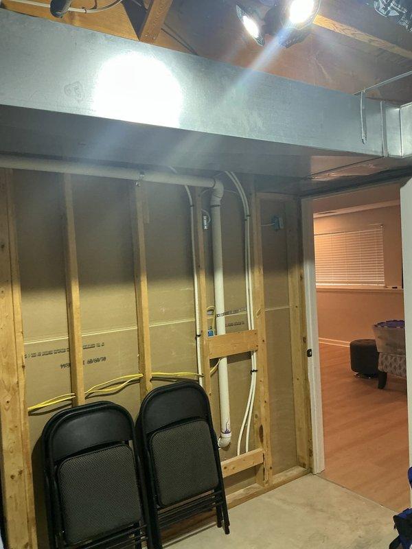 Provided quote for electrical outlet replacement in finished living area and installation of light fixture in unfinished basement space with exposed framing. Assessment included evaluation of existing electrical infrastructure, including conduit routing through wall studs and proximity to HVAC ductwork in basement area.