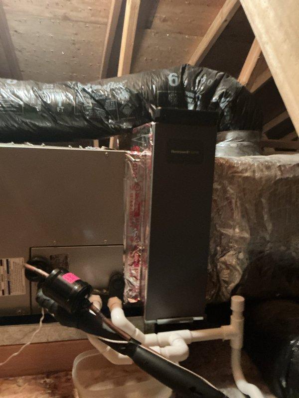 Installed media cabinet in attic to house HVAC controls and equipment components. Integrated Honeywell Home control unit with existing furnace system, routing flexible ductwork and establishing proper connections to air handler. Installed condensate drainage system with PVC piping, elbows, and collection pan to manage moisture removal. Secured all refrigerant lines with appropriate insulation, routed electrical connections, and verified proper operation of all integrated components within the attic-mounted system.