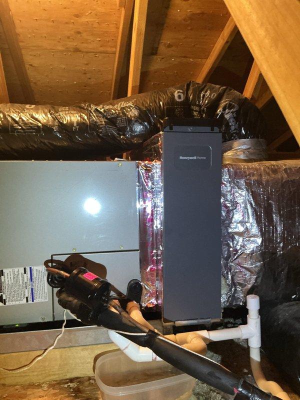 Installed media cabinet in attic to house HVAC controls and equipment components. Integrated Honeywell Home control unit with existing furnace system, routing flexible ductwork and establishing proper connections to air handler. Installed condensate drainage system with PVC piping, elbows, and collection pan to manage moisture removal. Secured all refrigerant lines with appropriate insulation, routed electrical connections, and verified proper operation of all integrated components within the attic-mounted system.