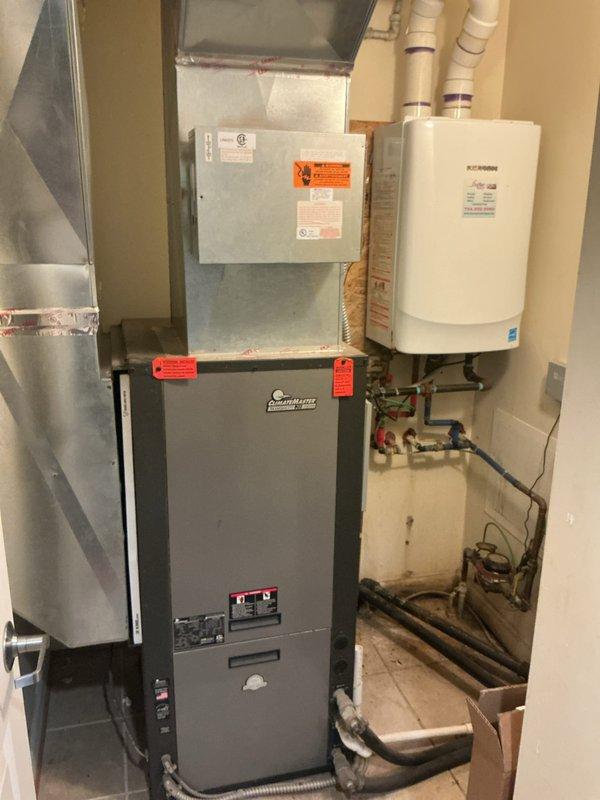 Responded to service call for tankless water heater not heating efficiently. Upon inspection, found unit operational with no visible leaks present. Examined internal components, copper piping connections, and electrical wiring; all appeared in normal working condition with standard oxidation on copper lines. Verified gas supply lines, water inlet/outlet connections with red and blue valve handles, and PVC venting system properly secured. Inspected adjacent furnace and HVAC equipment in utility room to ensure no interference with tankless unit operation. Documented equipment condition with photographs showing proper installation and component arrangement. Unit tested and found functioning within normal parameters at time of service.