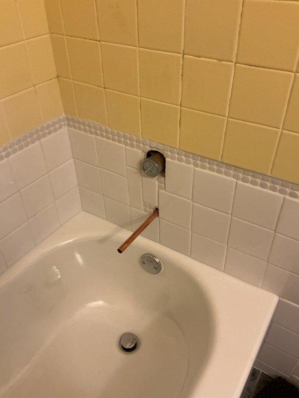 Completed return trip to connect valve from previous installation. Successfully installed and connected chrome-finished single-handle control valve and tub spout assembly on tiled bathroom wall. Verified proper water flow and operation of all fixtures.