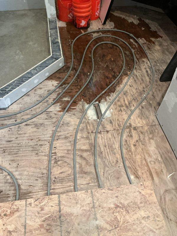 Responded to service call for reported boiler leak in basement of residential property. Upon inspection, identified leak originating from compromised hose connection on 10+ year old boiler system. Examined radiant heating system components and associated piping infrastructure. Assessed condition of affected flooring area showing moisture damage and verified extent of water intrusion. Inspected ceiling cavity and structural elements for secondary water damage. Documented system configuration and leak source with photographic evidence. Repaired faulty hose connection, pressure tested system to verify seal integrity, and confirmed proper operation of boiler unit. Monitored system through complete heating cycle with no further leakage detected.
