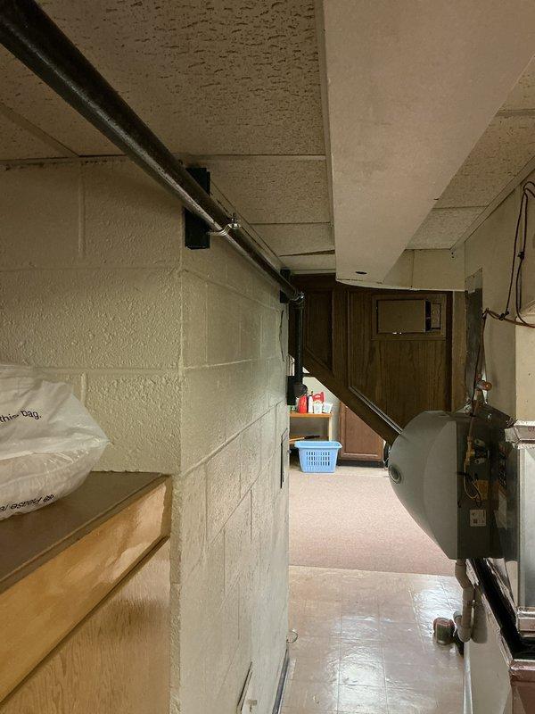 Assessed non-operational 14-year-old generator unit located outdoors for replacement estimate. Documented existing equipment condition and surrounding mechanical systems including HVAC components and water heater in basement utility area to determine installation requirements and specifications for new generator system.