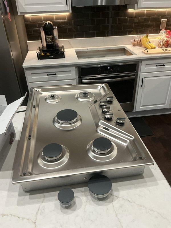 Installed new gas line from main supply to kitchen and completed installation of customer-supplied five-burner gas cooktop in white marble countertop. No existing gas line was present at the location, requiring full line run from source to appliance. Performed proper connections, tested all burners for functionality, and verified system integrity with leak detection procedures.