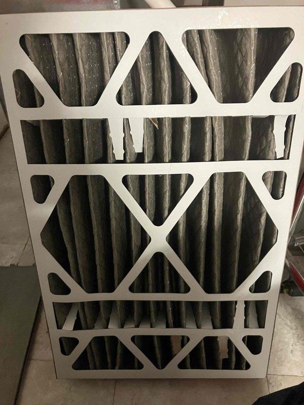 Responded to no-cool complaint on 1-year-old air conditioning system at office location. Upon arrival, confirmed outdoor condenser unit was not engaging when thermostat called for cooling, though wall control showed proper mode switching with audible click. 

Performed visual inspection of outdoor unit and discovered heavily soiled condenser coil with significant dirt, dust, and debris accumulation restricting airflow. Found additional organic debris including leaves and twigs collected at base of unit. Indoor air filter also showed loading with dust and particles.

Cleaned condenser coil thoroughly to restore proper airflow and heat transfer capability. Removed all debris from base of outdoor unit. Replaced indoor air filter with clean filter. Cycled system through cooling mode and verified outdoor condenser now engages properly when thermostat calls for cooling. Confirmed adequate airflow across coil and normal system operation. Unit cooling effectively with no further issues observe