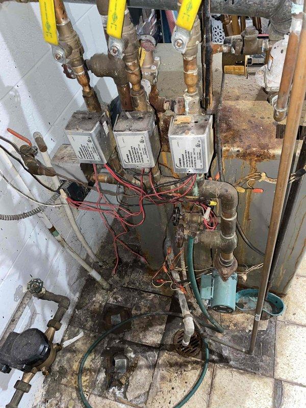 Provided comprehensive estimate for complete boiler replacement of 66-year-old non-operational heating system showing extensive deterioration, including severely corroded control panel, aged mechanical components, and outdated piping configuration. Assessment included evaluation of existing gas valves, electrical controls, circulator pump, expansion tank, and associated plumbing infrastructure throughout basement utility area. Estimate encompasses removal of failed equipment and installation of new boiler system with updated controls and necessary piping modifications to restore residential heating functionality.