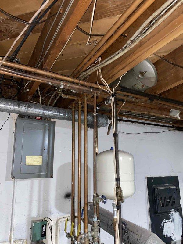 Provided comprehensive estimate for complete boiler replacement of 66-year-old non-operational heating system showing extensive deterioration, including severely corroded control panel, aged mechanical components, and outdated piping configuration. Assessment included evaluation of existing gas valves, electrical controls, circulator pump, expansion tank, and associated plumbing infrastructure throughout basement utility area. Estimate encompasses removal of failed equipment and installation of new boiler system with updated controls and necessary piping modifications to restore residential heating functionality.