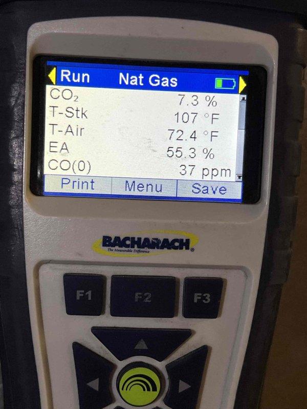 Completed Gold Furnace Inspection on 14-year-old unit located in basement. Replaced humidifier pad and furnace filter per customer request. Performed comprehensive combustion analysis using Bacharach analyzer, recording CO₂ at 7.3%, stack temperature at 107°F, ambient air temperature at 72.4°F, excess air at 55.3%, and carbon monoxide at 37 ppm. Verified surge protector (Supco SCM150, 120/240V single phase, 150,000A surge current rating) operational with green LED indicator illuminated. All measurements within acceptable operating parameters, and equipment functioning properly at time of inspection.