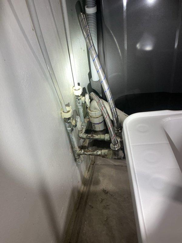 Completed on-site assessment of plumbing configuration conflict where existing water supply lines and PVC drain connections protruding from floor were preventing relocation of stackable washer/dryer unit that was blocking side door access. Evaluated current utility sink installation with existing copper water supply lines, braided flex connectors, and floor-mounted P-trap assembly. Provided professional recommendations for reconfiguring water supply and drain piping to allow appliance repositioning while maintaining functionality of utility sink, including options for relocating stub-outs and drain connections to accommodate both fixtures in desired layout.