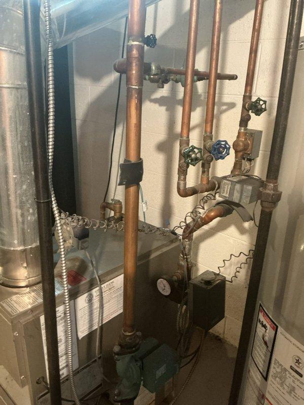 Responded to a water leak at boiler system where a valve was actively leaking. Upon inspection, identified the source as a faulty shut-off valve on the copper supply piping connected to the boiler circulator pump assembly. Tightened valve packing nut and verified leak was stopped. Inspected surrounding copper piping, brass fittings, and circulator pump for additional signs of corrosion or leakage; all components found to be in acceptable working condition. Removed collection bucket and advised monitoring system for 24-48 hours to ensure leak has been fully resolved.