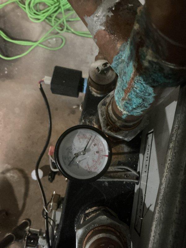 Completed comprehensive Gold preventative maintenance inspection on an 8-year-old residential boiler system. Performed thorough visual examination of all major components including heat exchanger, burner assembly, pressure gauge, circulation pump, and associated piping systems. Noted significant surface corrosion and oxidation present on pump housing and related metal fittings, though equipment remains operational. Inspected insulated supply piping showing rust staining on exterior wrapping material at seam locations. Verified pressure gauge functionality and checked all mechanical connections for integrity. Tested system operation and confirmed proper function of all components. Documented equipment condition with photographs for maintenance records. System currently operating as designed with no immediate service requirements identified, though corrosion patterns should be monitored during future inspections.