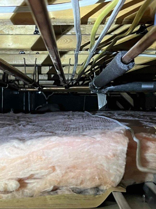 Responded to report of dripping water from HVAC furnace line in basement ceiling. Upon inspection, accessed crawl space above basement and located source of water leak at condensate drain line connection near five-year-old furnace system. Examined PVC condensate piping, drain trap, and associated connections throughout attic space. Identified loose fitting at condensate line junction causing intermittent dripping. Tightened connection, verified proper drain line pitch and trap function. Inspected insulation for water damage and confirmed no secondary leaks present. Tested system operation and monitored condensate flow to ensure proper drainage with no further leaking. Photographed affected area and repair for documentation purposes.