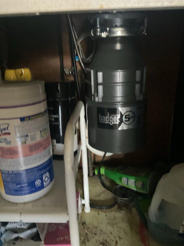 Responded to priority service call for garbage disposal maintenance on first floor kitchen unit. Upon arrival, inspected Badger 5 disposal system mounted beneath utility sink, noting visible staining and wear in basin around drain area. Performed comprehensive assessment of disposal unit, electrical connections, and associated PVC drainage plumbing. Verified proper mounting, tested operational functionality, and confirmed all connections secure. Unit restored to full working order with no leaks detected.