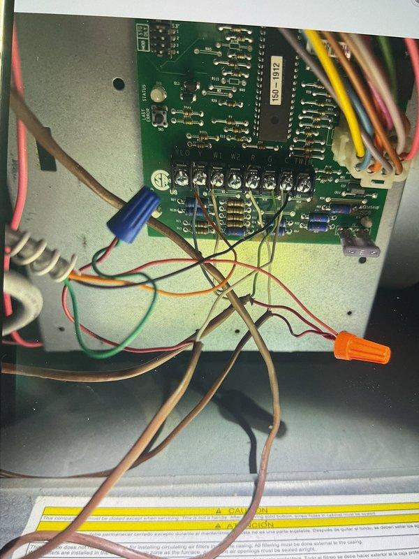 Responded to no cooling complaint on 4-year-old attic-mounted air conditioning system blowing hot air. Upon inspection, accessed control board and wiring assembly within air handler. Diagnosed failed control board based on visual inspection of PCB components and wire connections. Documented existing wiring configuration showing multiple wire connections to circuit board including thermostat wiring, power connections, and component control wires. Control board exhibited signs of failure requiring replacement to restore cooling operation.