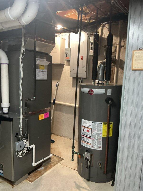 Responded to no hot water complaint at residential property. Inspected water heater unit located in basement, manufactured 04/03/2015, confirming lack of hot water production. Documented existing equipment condition with photographs showing water heater installation alongside furnace in utility room. Discussed water heater replacement options with homeowner due to age and failure of unit to produce hot water.
