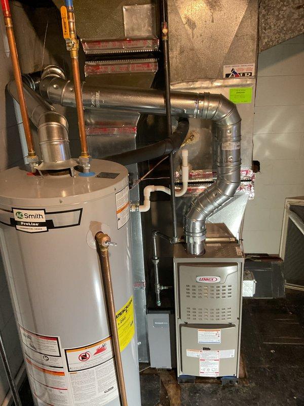 Completed full furnace installation in basement mechanical room. Installed new Lennox furnace unit with complete metallic ductwork configuration, including curved and straight sections with proper joints and connections. Routed silver galvanized ductwork from furnace to distribution points with appropriate elbow fittings. Connected air handler/evaporator coil unit with copper refrigerant lines and brass fittings. Installed gas shut-off valve and made all necessary gas line connections. Verified proper clearances around existing AO Smith water heater and coordinated all mechanical, electrical, and gas connections per code requirements. All ductwork secured and sealed, system tested for proper operation and airflow.
