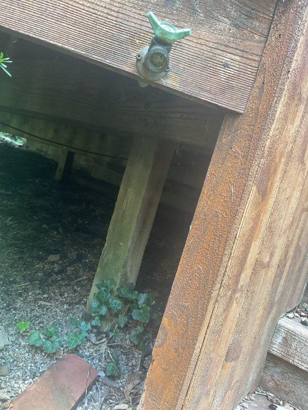 Responded to multiple plumbing issues throughout the property. Addressed first-floor bathroom cold water tap with reduced flow, identifying that water control required adjustment at basement shutoff valve due to absence of local fixture shutoff. Investigated and repaired non-functional front exterior faucet. Primary work involved replacing broken waterline feeding outdoor tap mounted on backyard deck structure, which had caused water damage evidenced by staining on wooden deck posts and interior ceiling water damage visible on acoustic tiles near glass block window. Documented existing water damage and completed waterline replacement to restore functionality to deck-mounted fixture. All affected fixtures tested and confirmed operational upon completion.