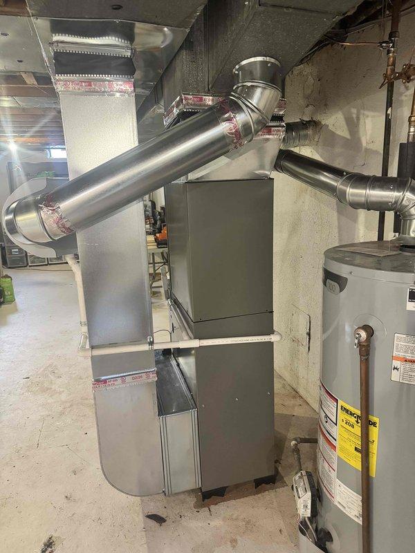 Completed full HVAC system installation including a 70,000 BTU furnace with humidifier and 2.5-ton air conditioning unit with rear discharge configuration. Installed new metallic ductwork with proper connections and transitions, positioned furnace on leveling blocks on concrete pad, and reconnected existing electrical components. Performed pressure testing using digital manometer to verify system operation, confirming proper static pressure readings at +0.050 inches water gauge. Obtained mechanical and electrical permits prior to installation. All equipment installed per manufacturer specifications and local code requirements, with system tested and operational upon completion.