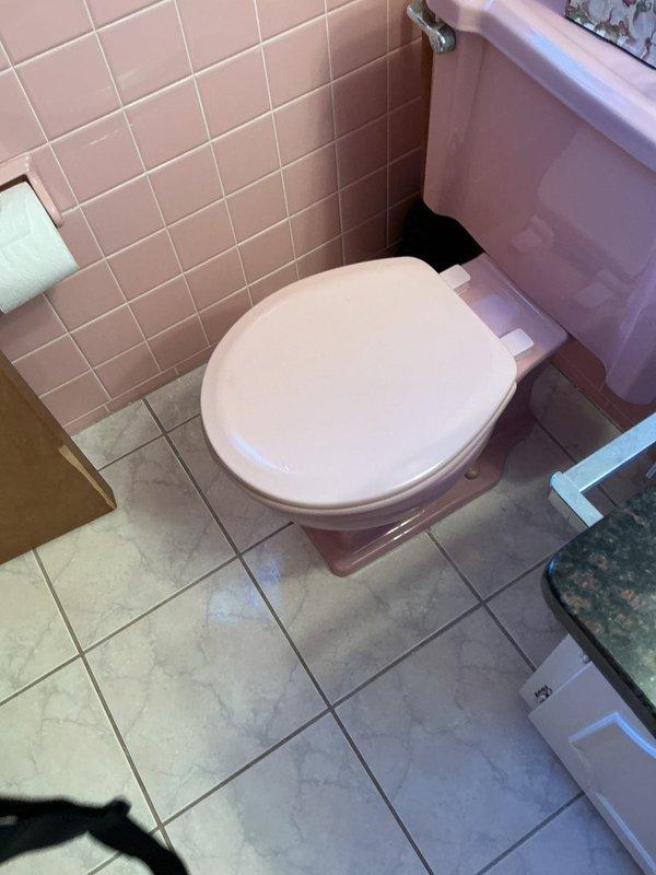 Responded to report of residue leaking from base of toilet in residential bathroom. Upon inspection, identified compromised wax ring seal causing water and waste material to seep from toilet base onto tile flooring. Removed toilet from floor flange, scraped old wax ring, inspected flange for damage, and installed new wax ring seal. Reset toilet, reconnected water supply line, tested for proper flush operation and verified complete seal with no leakage. Observed water staining on kitchen ceiling directly below bathroom, indicating previous leak penetration through subfloor. Advised homeowner of ceiling damage requiring repair once area fully dries.