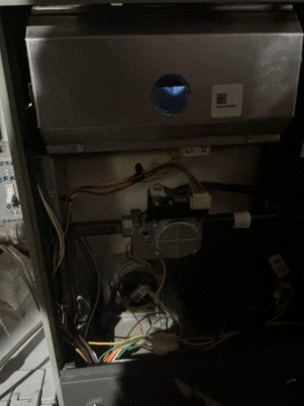Completed comprehensive Gold Furnace Inspection on residential HVAC system including 2018 furnace with coil located in basement and 5-year-old outdoor air conditioning unit. Performed thorough examination of furnace internal components including gas valve assembly, burner operation, heat exchanger condition, blower motor function, and electrical connections. Inspected multicolored control wiring, copper refrigerant lines, and condensate drainage system. Verified proper combustion and air flow through viewing window. Evaluated outdoor condensing unit positioned on concrete pad, checking condenser coil condition, fan motor operation, electrical disconnect, and refrigerant line connections. Documented equipment condition through photographs showing internal furnace components and external AC unit installation. All systems operational and functioning within normal parameters. Maintenance completed per Gold service plan specifications.