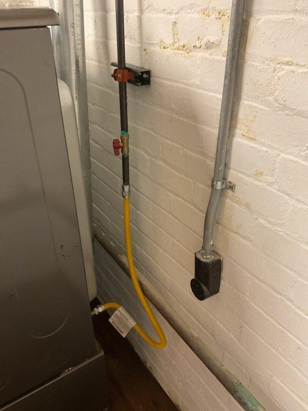 Completed gas line repairs and dryer hookup in basement utility area, installing flexible yellow CSST gas line with appropriate black shut-off valves featuring safety handles for code compliance. All connections were pressure tested, secured to wall with proper brackets, and verified for safe operation of gas appliances.