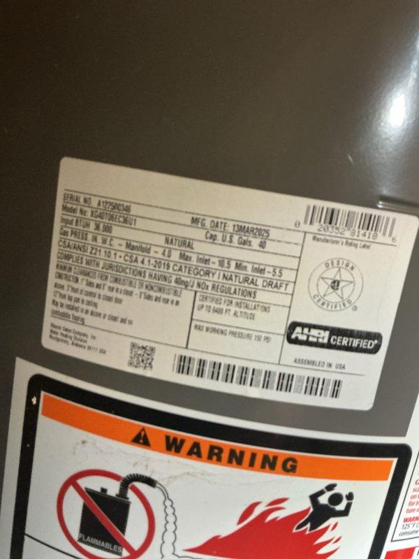 Completed annual hot water boiler inspection and tune-up on a 1-year-old 96,000 BTU/h natural gas unit located in utility room. Verified operational status of control board with digital display reading 165°F, inspected all electrical connections and wiring harnesses, and examined gas valve assembly and manifold components. All safety controls, warning labels, and AHRI-certified specifications confirmed in proper working order with no deficiencies noted.