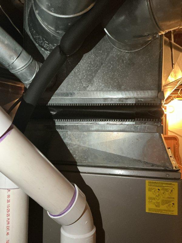 Responded to customer complaint of air conditioning system blowing warm air. Evaluated 10+ year old cooling equipment located in basement, including air handler with finned coil assembly and associated ductwork connections. Inspected furnace/air handler unit, condensate drainage system with PVC piping, flexible and rigid ductwork transitions, and electrical connections. Documented existing HVAC system configuration and equipment condition through detailed assessment. Provided comprehensive replacement estimate for cooling system and recommended surge protector installation to protect new equipment from electrical damage.