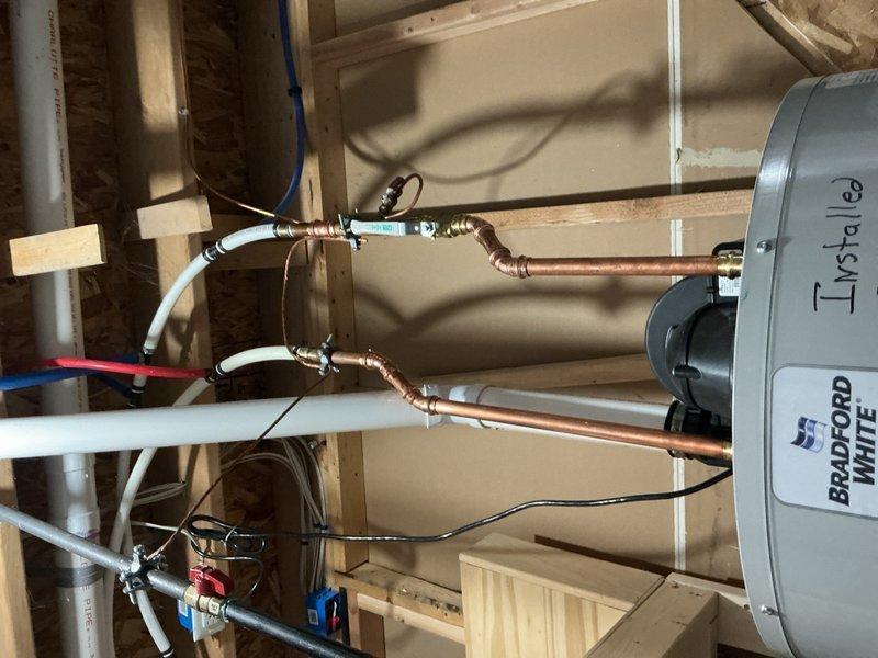 Completed Gold Furnace Inspection on residential heating system located in basement. Upon arrival, homeowner indicated furnace was operational but uncertain of unit age, estimating over 10 years old. Performed comprehensive visual inspection of furnace components including burner assembly, blower motor, heat exchanger, and all associated mechanical and electrical connections. Examined gas burners and flame sensors, noting proper positioning and alignment. Inspected heat exchanger for signs of deterioration, observing surface corrosion consistent with age and normal wear patterns on cylindrical heat exchange components. Verified blower motor housing and mounting hardware secure and operational. Checked all electrical wiring connections including control wires and safety circuits. Documented current condition of unit with photographs showing internal furnace components, burner assembly with visible flame sensors, heat exchanger condition, and blower motor assembly. Also photographed asso