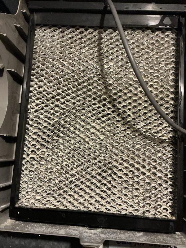 Completed comprehensive Gold AC Inspection on 13-year-old air conditioning system located in basement. Performed full system tune-up including inspection of outdoor condenser unit positioned on concrete pad adjacent to building exterior, verified proper operation of condenser fan and examined ventilation components. Inspected evaporator coil and honeycomb mesh filter media within air handler, noting mineral deposit accumulation on filter surface consistent with normal operation over service interval. Checked refrigerant lines, electrical connections, and condensate drainage system. Confirmed last service was performed approximately six months prior as requested. All components operating within normal parameters with no immediate repairs required. System cooling efficiently with no reported performance issues. Recommended continued routine maintenance schedule to ensure optimal performance and longevity of aging equipment.